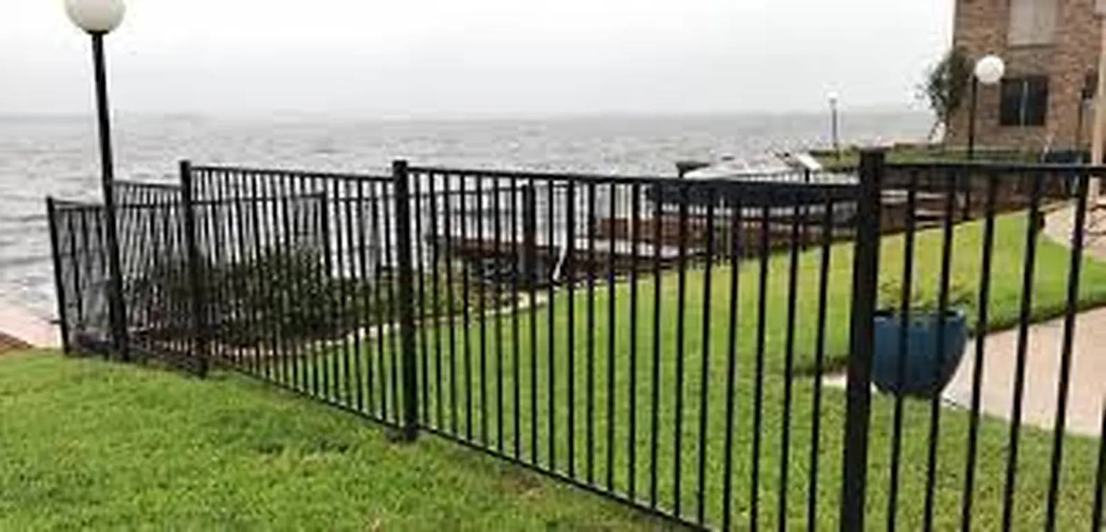 Hand-forged iron entry gate with matching side fencing